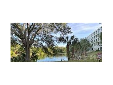 Building exterior overlooking the lake, highlighted by mature trees, offering a serene view and natural light at 701 S Madison Ave # 515, Clearwater, FL 33756