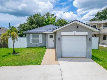 Charming single-story home featuring a well-maintained lawn, a one car garage, and freshly painted grey exterior at 719 58Th S St, Gulfport, FL 33707