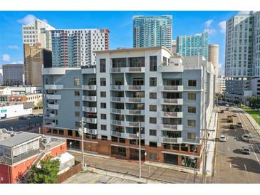 Condo building with balconies and city views against a vibrant blue sky on a busy street with cars passing by at 1108 N Franklin St # 502, Tampa, FL 33602