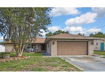 Charming single-story home with a brick facade, large front yard, and two-car garage, creating a welcoming curb appeal at 11187 Blythville Rd, Spring Hill, FL 34608