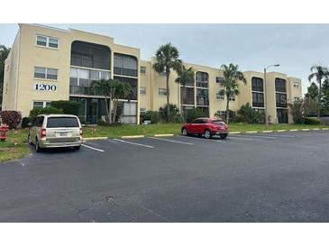 Condo building featuring well-kept landscaping and an expansive parking lot at 11485 Oakhurst Rd # 1200-214, Largo, FL 33774