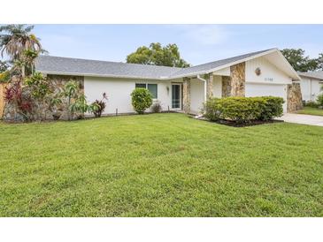 Charming single-story home with stone accents and a well-maintained lawn at 11762 Barb Ct, Seminole, FL 33778