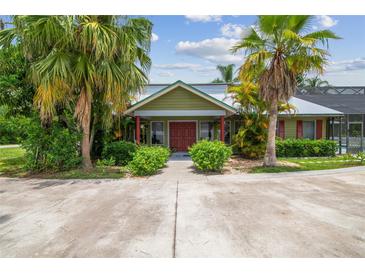 Charming home with lush landscaping, mature palms, and a welcoming front entrance at 18914 Geraci Rd, Lutz, FL 33548