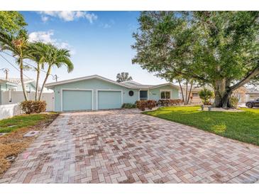 Charming home with a brick driveway, beautiful landscaping and a spacious two-car garage at 352 La Hacienda Dr, Indian Rocks Beach, FL 33785