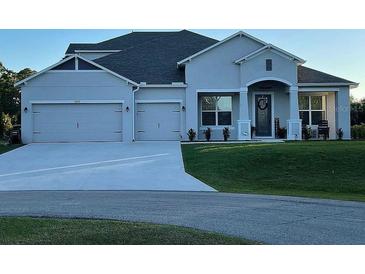 Charming single-story home with manicured lawn and a three-car garage, perfect curb appeal at 3895 Tate Ct, North Port, FL 34288