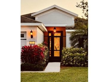 Charming front door with stained glass, surrounded by vibrant landscaping and an inviting walkway at 5103 98Th E Ave, Parrish, FL 34219