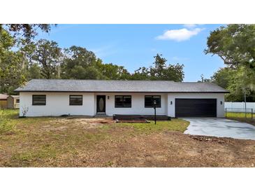A well-maintained ranch home with neutral colors, black trim and garage door on a spacious lot at 603 Amana Ave, Brandon, FL 33510