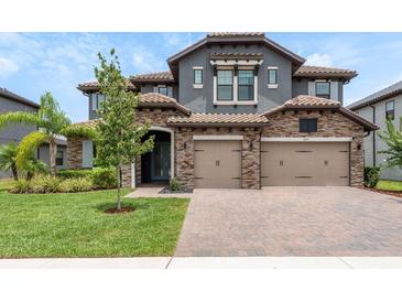 Two-story home with stone accents, a two-car garage, and a well-manicured lawn at 6109 Marsh Trail Dr, Odessa, FL 33556
