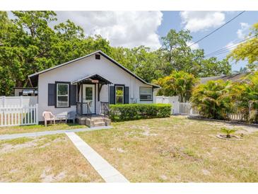 Charming cottage-style home with a well-manicured lawn and a classic white picket fence at 1235 Bass Blvd, Dunedin, FL 34698