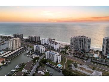 Breathtaking aerial view of beachfront condos, marina, and shoreline at sunset at 1581 Gulf Blvd # 403N, Clearwater Beach, FL 33767