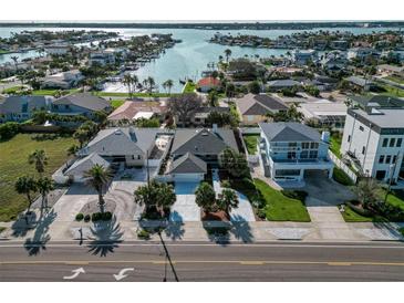 Aerial view of waterfront homes featuring lush landscaping, private docks, and beautiful water views at 2801 Gulf Blvd, Belleair Beach, FL 33786