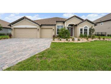 Charming single-story home with a well-manicured lawn, paver driveway and a lovely garden at 33219 Kateland Dr, Wesley Chapel, FL 33545