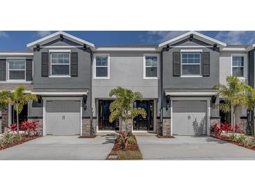 Charming townhomes with two-car garages, stone accents and manicured landscaping create curb appeal at 4444 Aqua Mirage St, Sarasota, FL 34238