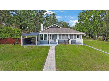 Charming single-story home with well-maintained lawn, covered parking, and classic architectural details at 4783 School Rd, Land O Lakes, FL 34638