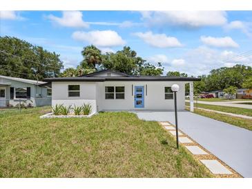 Charming single-story home with a blue front door and a well-manicured lawn at 6816 S Hesperides St, Tampa, FL 33616