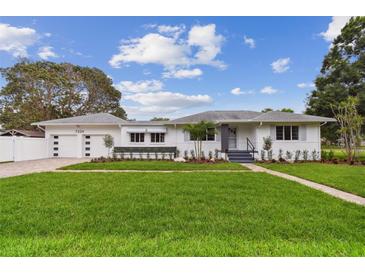 Charming home with a well-manicured lawn, neutral color scheme, and a beautiful garden in front at 7224 Park S St, St Pete Beach, FL 33707