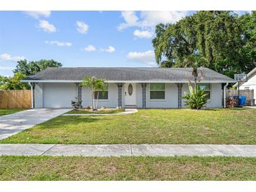 Charming single-story home featuring a well-manicured lawn, decorative ironwork, and a welcoming front entrance at 9053 Hickory Cir, Tampa, FL 33615