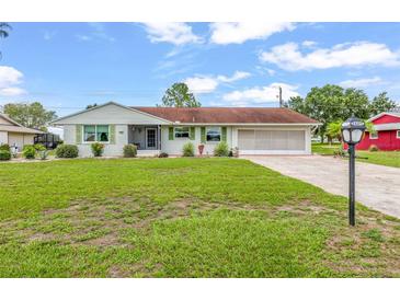 Charming single-story home with manicured front yard and attached two-car garage at 1609 Pebble Beach N Blvd, Sun City Center, FL 33573