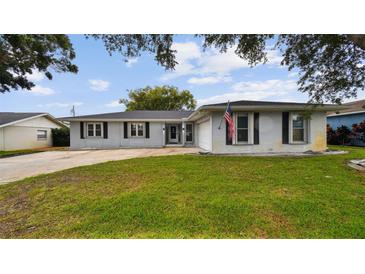 Charming one-story home with a well-maintained lawn and a classic American flag displayed at 1675 Eden Ct, Clearwater, FL 33756