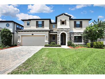 Stunning two-story home featuring stone accents, a two-car garage, and beautifully landscaped front yard at 1821 Cherry Walk Rd, Lutz, FL 33558