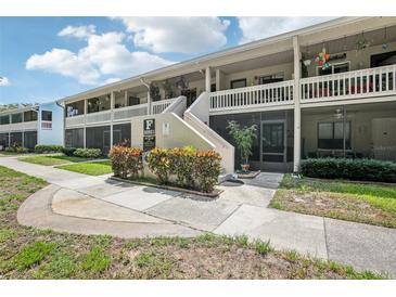 Inviting condo exterior featuring screened patios and well-maintained landscaping at 20921 Haulover Cv # 8, Lutz, FL 33558