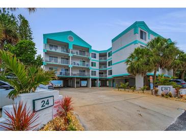 Beautiful, multi-story beach condo with private parking, lush landscaping, and teal and white color scheme at 24 Gulf Blvd # 1C, Indian Rocks Beach, FL 33785