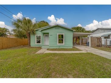 Charming light green bungalow with a cozy carport and beautiful lawn and palm trees at 2931 23Rd N St, St Petersburg, FL 33713