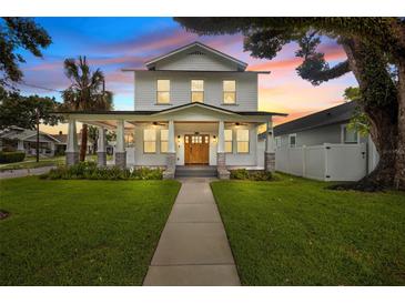 Charming two-story home showcasing a meticulously landscaped yard and inviting covered porch with stylish columns at 502 E Robles St, Tampa, FL 33602