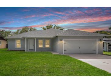 Charming single-story home with a well-manicured lawn, attached garage, and a colorful sunset backdrop at 5319 Lantana St, Zephyrhills, FL 33542