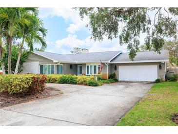 Charming single-story home with a well-manicured front yard and a circular driveway leading to the two-car garage at 5871 Oakhurst Dr, Seminole, FL 33772