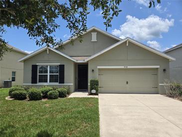 Charming single-story home with a well-maintained lawn, two car garage and manicured landscaping at 9724 Troncais Cir, Thonotosassa, FL 33592