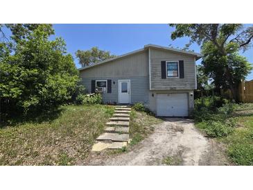 Two-story home featuring a quaint entryway and attached one car garage at 1107 Goshen Rd, Tarpon Springs, FL 34689