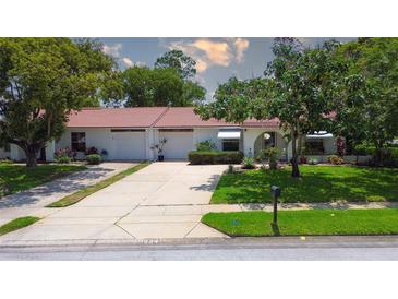 Charming single story home featuring a red tile roof, white exterior and two-car garage at 11334 Winwood Pl # 11334, Port Richey, FL 34668