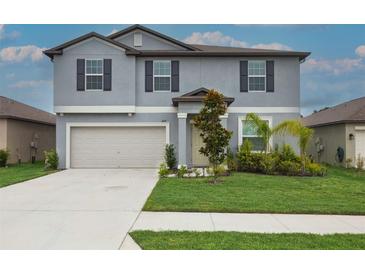 Charming two-story home featuring a well-manicured lawn, attached two-car garage, and appealing curb appeal at 11693 Lavender Loop, Spring Hill, FL 34609