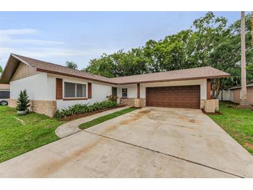 Charming single-story home with a well-manicured lawn and a two-car attached garage at 1558 Cottonwood Ter, Dunedin, FL 34698