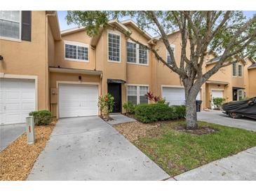 Charming townhome with a one-car garage, well-maintained landscaping, and inviting front entrance at 16314 Parkstone Palms Ct, Tampa, FL 33647