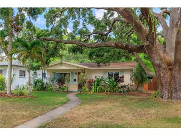 Charming one-story home with mature trees and lush landscaping at 4028 Queen N St, St Petersburg, FL 33714