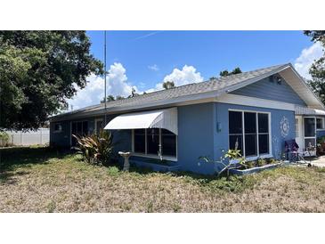 Charming single-story home with a blue exterior, awning-covered window, and partially landscaped yard at 5719 13Th E St, Bradenton, FL 34203