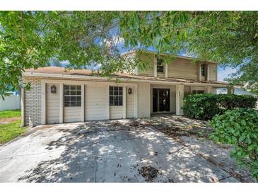 Two-story home featuring a brick and wood exterior with a two car garage and mature trees at 7309 Monterey Blvd, Tampa, FL 33625