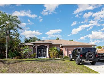 Charming single-story home with mature landscaping, a front lawn, and a decorative front door at 1162 Music Ln, North Port, FL 34286