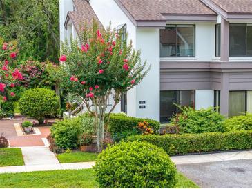 Charming townhouse exterior with lush landscaping, including a flowering tree at 1712 Lake Cypress Dr # 1604, Safety Harbor, FL 34695