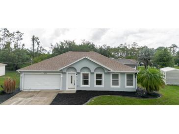 Charming single-story home with manicured landscaping, attached garage, and freshly painted exterior at 4959 Cromey Rd, North Port, FL 34288