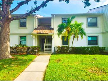 Inviting two-story condo featuring lush landscaping and a shared staircase entrance, perfect for comfortable living at 106 Windward Pl # 106, Oldsmar, FL 34677