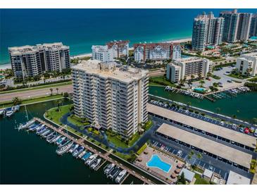 Stunning aerial view of a beachfront condominium with a private marina, pool, and beautiful coastal scenery at 1621 Gulf Blvd # 407, Clearwater Beach, FL 33767