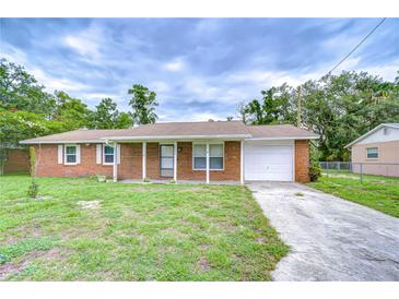 Charming brick home featuring a well-maintained lawn and a one-car garage at 40019 Pretty Redbird Rd, Zephyrhills, FL 33540