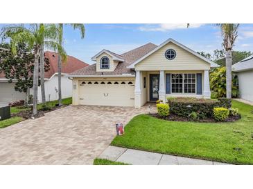 Charming single-Gathering home features a well-maintained lawn, brick driveway, and attached two-car garage at 4400 English Turn Way, Wesley Chapel, FL 33543