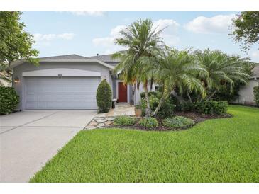Charming single-story home with a well-manicured lawn and lush landscaping at 4926 Pennecott Way, Wesley Chapel, FL 33544