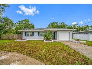 Charming single-story home with a well-manicured lawn, attached garage, and blue shutters at 538 Bamboo Ln, Clearwater, FL 33764