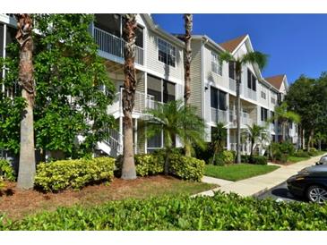 Attractive condo building showcasing private balconies and mature landscaping with tropical plants at 850 S Tamiami Trl # 424, Sarasota, FL 34236