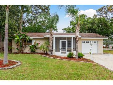 Charming single-story home with well-maintained landscaping and inviting screened entrance at 10623 103Rd St, Largo, FL 33773